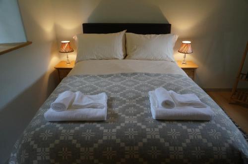 a bedroom with a bed with two towels on it at Gatekeepers Lodge, Dyrham Park - Private & Self Contained, deluxe accommodation, 15 mins from Bath in Dyrham