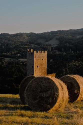 a stack of hay bales on a hill with a castle at La Casina in Stia