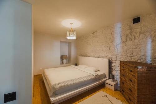 a bedroom with a bed and a stone wall at Kuressaare Turu Apartment in Kuressaare