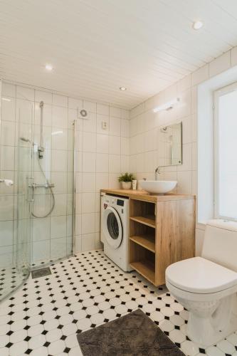 a bathroom with a toilet a sink and a washing machine at Kuressaare Turu Apartment in Kuressaare