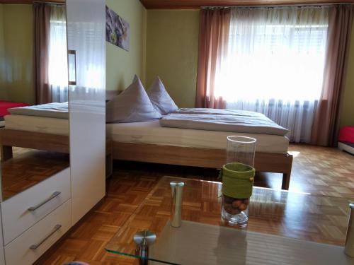 a room with a bed and a glass on a table at Hotel Mainperle in Wertheim