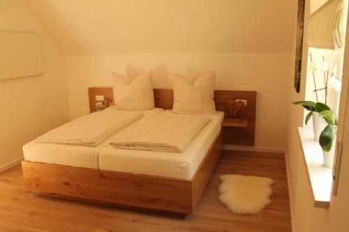 a bedroom with a bed with white sheets and a rug at Frankenwald Chalets - Ferienhaus Hans in Wilhelmsthal