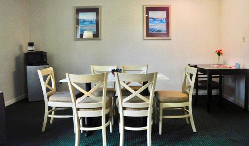 a dining room with a table and chairs and a table and a table and chairs at Azalea Inn & Suites in Wilmington