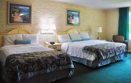 Tempat tidur dalam kamar di Azalea Inn & Suites