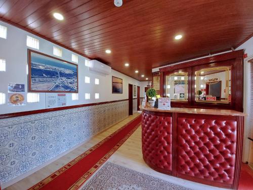 a bar in a restaurant with a red booth at VILA FORMOSA AL-Estabelecimento de Hospedagem,Quartos-Rooms in Monte Gordo