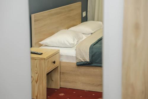 Araks Hotel Complex في غيومري: غرفة نوم صغيرة مع سرير وموقف ليلي