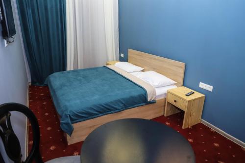 Araks Hotel Complex في غيومري: غرفة نوم صغيرة مع سرير وطاولة