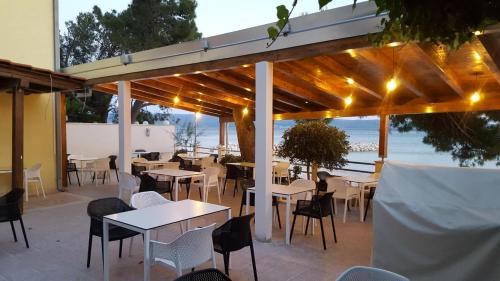un restaurante con mesas y sillas y vistas al océano en Apartments & Rooms Baltazar, en Podstrana