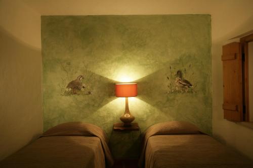 a bedroom with two beds with a lamp on the wall at Monte Do Areeiro in Coruche