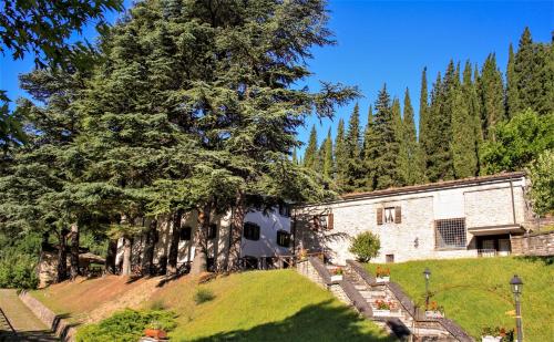 una casa con un albero accanto a un edificio di Il Palazzo Ridracoli a Bagno di Romagna