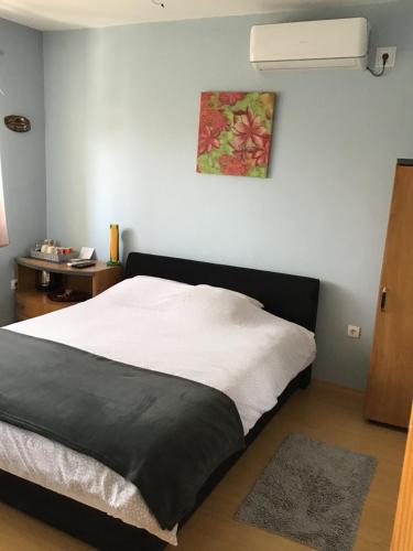 een slaapkamer met een bed met een zwart-witte deken bij Bingo Apartments in Banja Luka