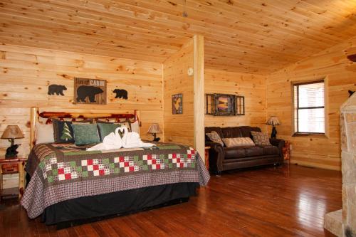 1 dormitorio con 1 cama y 1 sofá en una cabaña en Endless Mountain Dreams en Gatlinburg