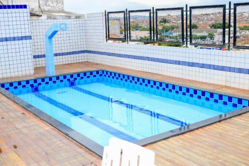 una gran piscina con azulejos azules en un edificio en Center Plaza Hotel, en Caruaru