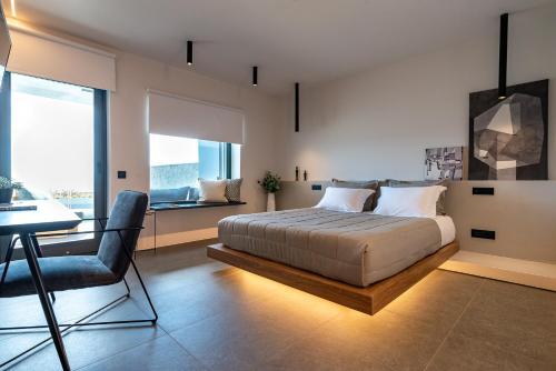 um quarto com uma cama, uma mesa e uma cadeira em Orion suites em Tinos Town