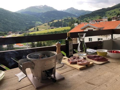 a grill on a table with meat and a bottle of wine at Casa Spel Mir in Disentis