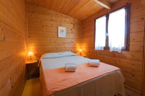 a bedroom with a bed in a wooden cabin at Herdade do Sardanito da Frente in Zambujeira do Mar