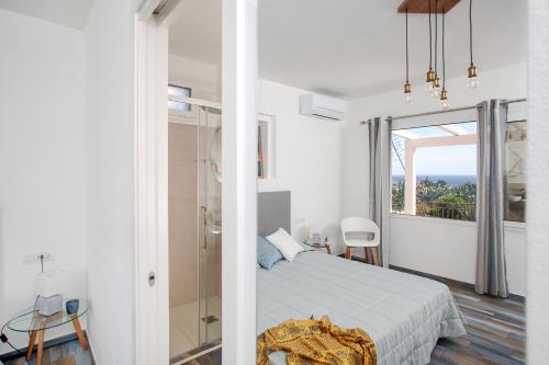a white bedroom with a bed and a window at B&B La Torre Elite in Santa Teresa Gallura
