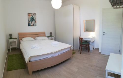 a bedroom with a bed and a desk and a mirror at Apartments Tinjarosa in Mundanije