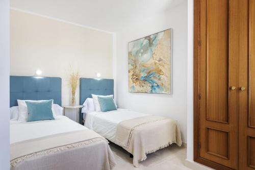 a bedroom with two beds and a painting on the wall at Villa Roble in Yaiza