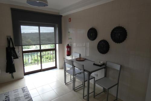 a kitchen with a table and chairs and a window at Casa Sandra - Apartamento Mariana in Lousã