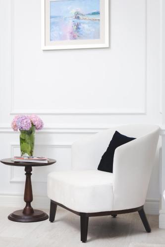 a white chair and a table with a vase of flowers at Boutique Hotel Vissi d'Arte in Budva