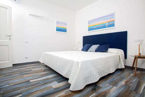 a bedroom with a bed with a blue headboard at B&B La Torre Elite in Santa Teresa Gallura