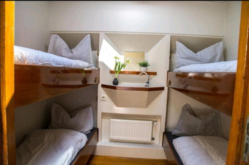 a room with three bunk beds and a radiator at Zeilschip De Hester in Kampen