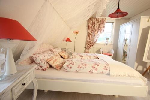 Un dormitorio con una cama blanca con almohadas y una ventana en Ferienidyll Aumühle, "Wiesengrund", en Rot am See