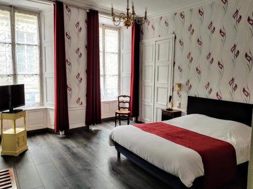 ヴァローニュにあるLogis Le Grand Hôtel du Louvreのベッドルーム(ベッド1台、赤いカーテン、テレビ付)