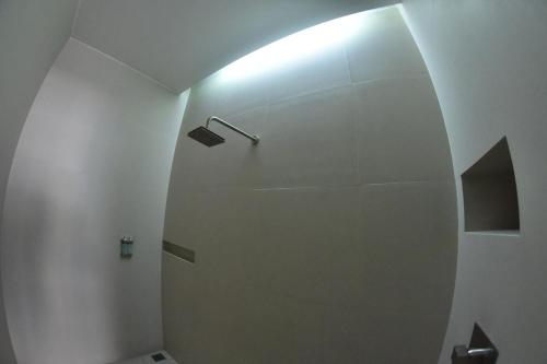 a bathroom with a white wall and a light at La Moraleja Love hotel in Mexico City