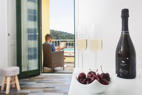 a bottle of wine and a bowl of cherries at B&B La Torre Elite in Santa Teresa Gallura