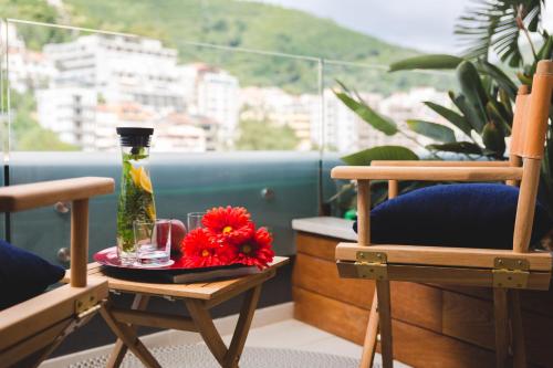 a table with a vase and flowers on a balcony at Boutique Hotel Vissi d'Arte in Budva