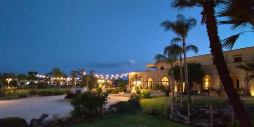 a building with palm trees and lights at night at Agriturismo Paradiso in Parabita