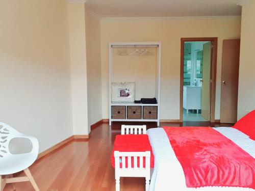 a bedroom with a bed with a red blanket and two chairs at Estrella Do Camiño in Caldas de Reis