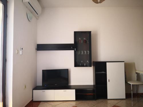 Apartment Plavia Biograd في بيوغراد نا مورو: غرفة معيشة مع تلفزيون وثلاجة