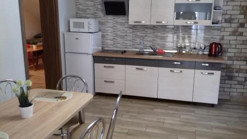 Rozalin的住宿－WYGODA，厨房配有白色冰箱和桌椅