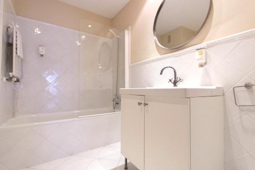 a white bathroom with a sink and a mirror at Apartment in the Centre in Madrid