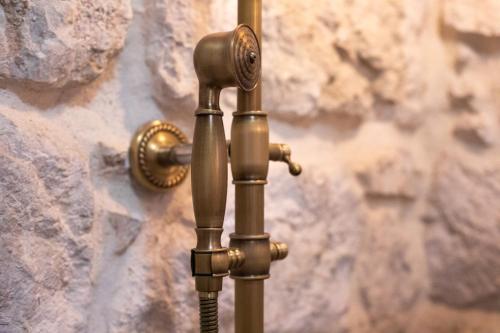 a bronze pipe attached to a stone wall at Ivićev san in Tučepi