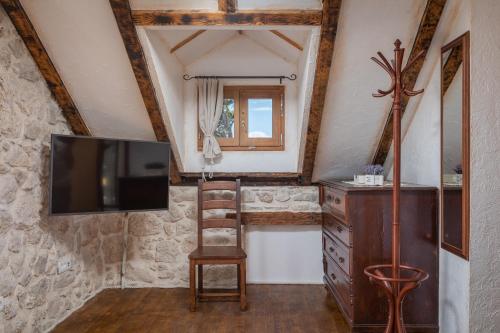 a living room with a tv and a wooden chair at Ivićev san in Tučepi