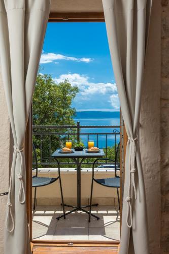 a table on a balcony with a view of the ocean at Ivićev san in Tučepi