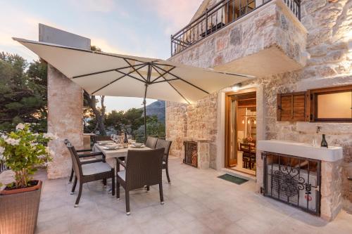 a patio with a table and an umbrella at Ivićev san in Tučepi