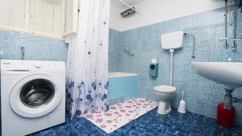 uma casa de banho com uma máquina de lavar roupa e um lavatório em Apartment Marko em Makarska