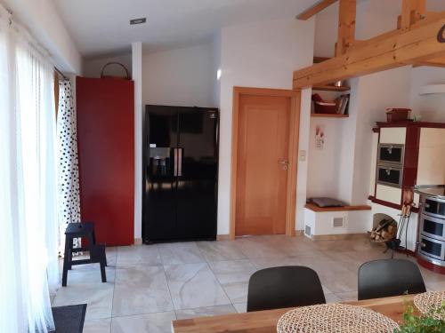 a living room with a black refrigerator and a table at Adliapartmán 2020 in Vlasenice