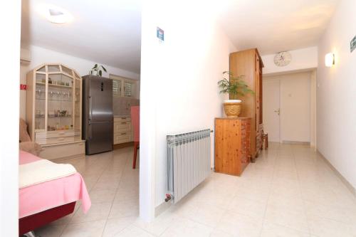 Il dispose d'une cuisine équipée d'un réfrigérateur noir et de carrelage blanc. dans l'établissement Apartment Marko, à Makarska