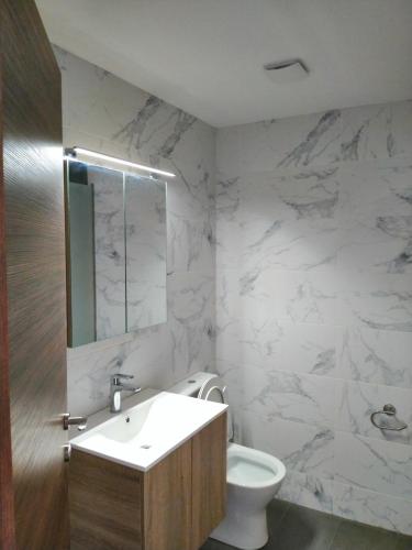 a white bathroom with a sink and a toilet at Gianni's Apartment By The Sea in Ammouliani