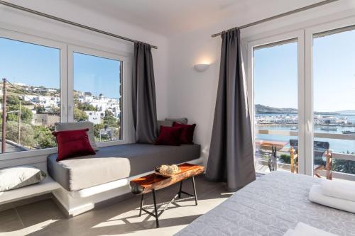 a bedroom with a bed and a large window at Magic View Suites Mykonos in Mýkonos City