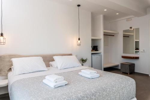 a bedroom with a bed with two towels on it at Magic View Suites Mykonos in Mýkonos City