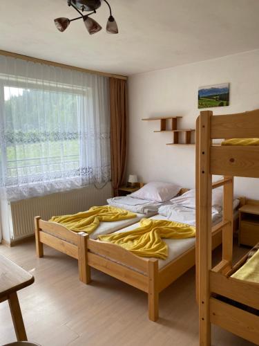 a bedroom with two bunk beds and a window at Agroturystyka u Czepiela in Ochotnica Górna