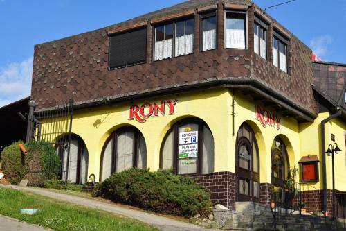 a yellow building with a rory sign on it at Penzion RONY in Radějov