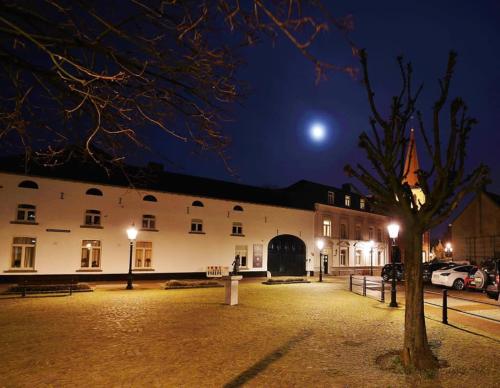 Un edificio de noche con la luna en el cielo. en B&B Laeve in de Brouwerie, en Geleen